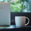 White mug beside laptop.